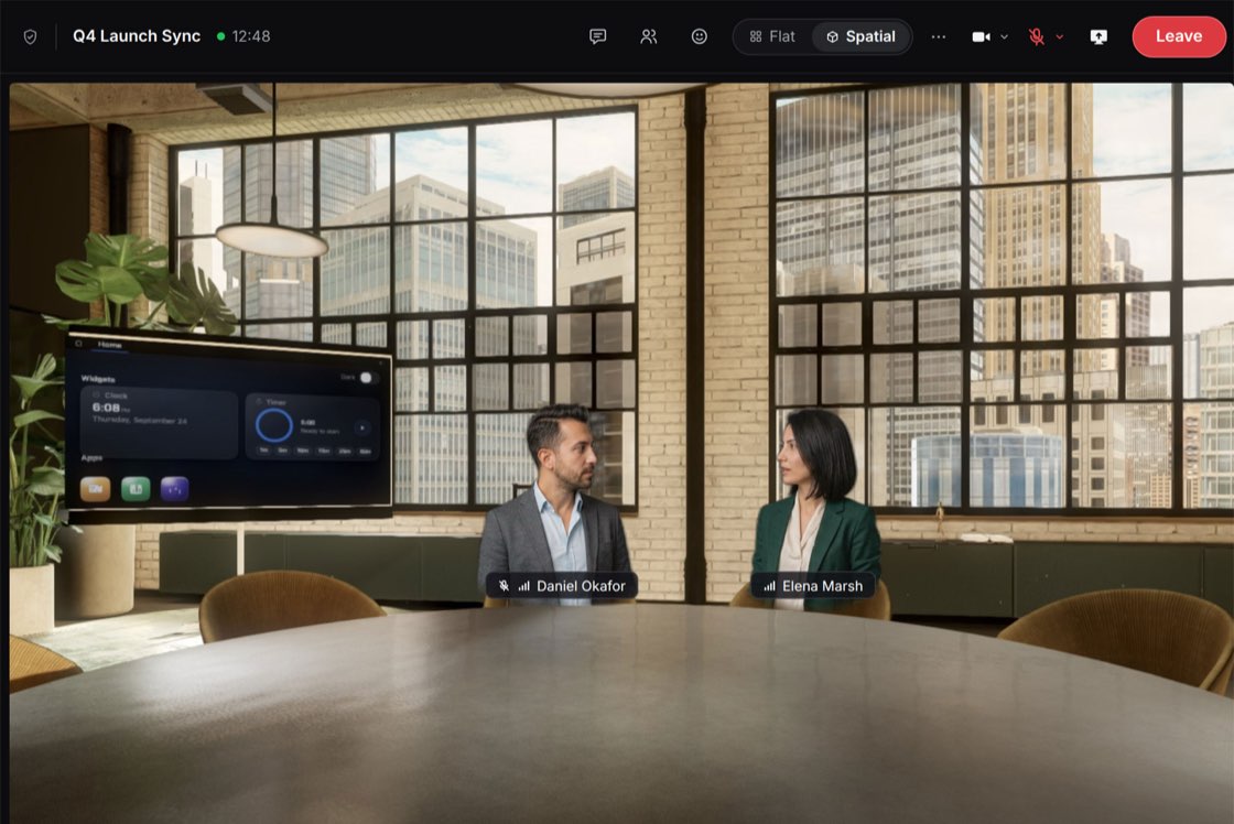 A spatial call in progress: two participants, Daniel Okafor and Elena Marsh, seated at a round table in a 3D loft meeting room with a wall display, and the call controls with Flat and Spatial views along the top.